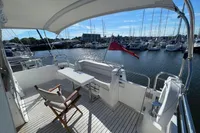 Deck view of 2007 Trader 42 yacht in marina, featuring seating and table.
