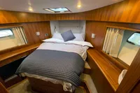 Luxurious cabin interior of 2007 Trader 42 yacht with cozy bed and wooden finish.