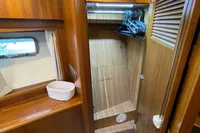 Wooden interior of a 2007 Trader 42 yacht with open closet and window.
