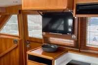 Interior of 2007 Trader 42 yacht with wooden cabinetry and mounted TV.
