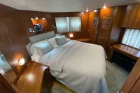 Luxurious bedroom interior on a 2007 Trader 42 yacht, featuring wood paneling and cozy bedding.