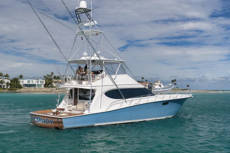 "slim Shady" Yacht Photos Pics 2015 Hatteras GT70 yacht cruising in clear blue waters near a tropical shoreline.