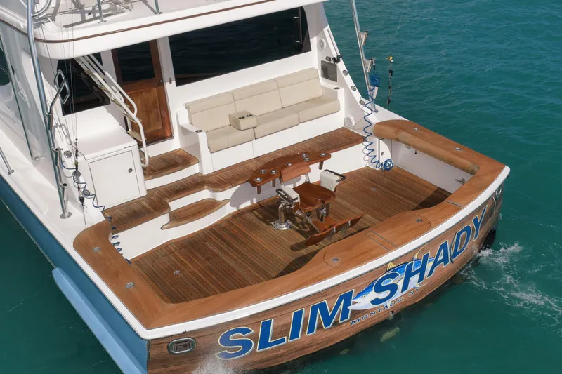 "slim Shady" Yacht Photos Pics 2015 Hatteras GT70 yacht with wooden deck, fishing chair, and cushioned seating.