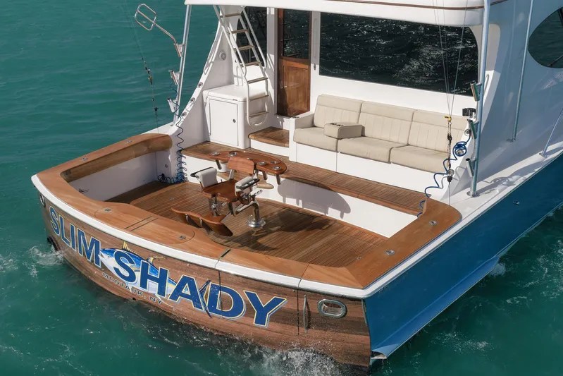 "slim Shady" Yacht Photos Pics 2015 Hatteras GT70 yacht with wooden deck, fishing chair, and cushioned seating.