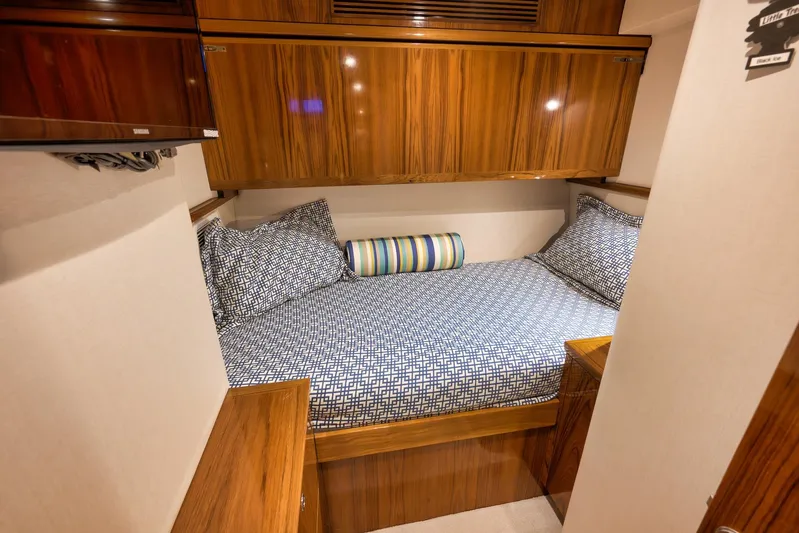 "slim Shady" Yacht Photos Pics Luxurious cabin interior of 2015 Hatteras GT70 yacht with wood finish and patterned bedding.