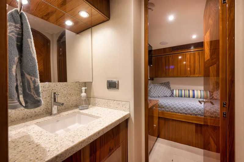 "slim Shady" Yacht Photos Pics Luxurious bathroom and bedroom interior of 2015 Hatteras GT70 yacht, featuring elegant wood finishes.