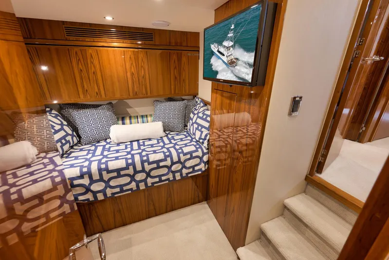 "slim Shady" Yacht Photos Pics Luxurious cabin interior of 2015 Hatteras GT70 yacht with patterned bedding and wall-mounted TV.