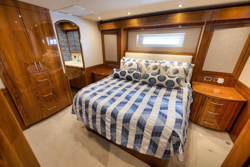 "slim Shady" Yacht Photos Pics Luxurious bedroom interior of 2015 Hatteras GT70 yacht with elegant wood finishes and nautical bedding.
