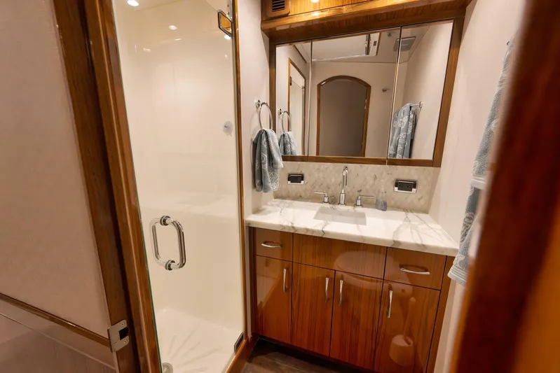 "slim Shady" Yacht Photos Pics Luxurious bathroom interior of 2015 Hatteras GT70 yacht with wooden cabinetry and glass shower.