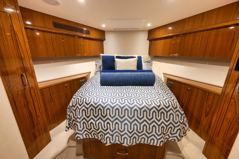 "slim Shady" Yacht Photos Pics Luxurious cabin interior of 2015 Hatteras GT70 yacht with elegant wood finish and patterned bedding.