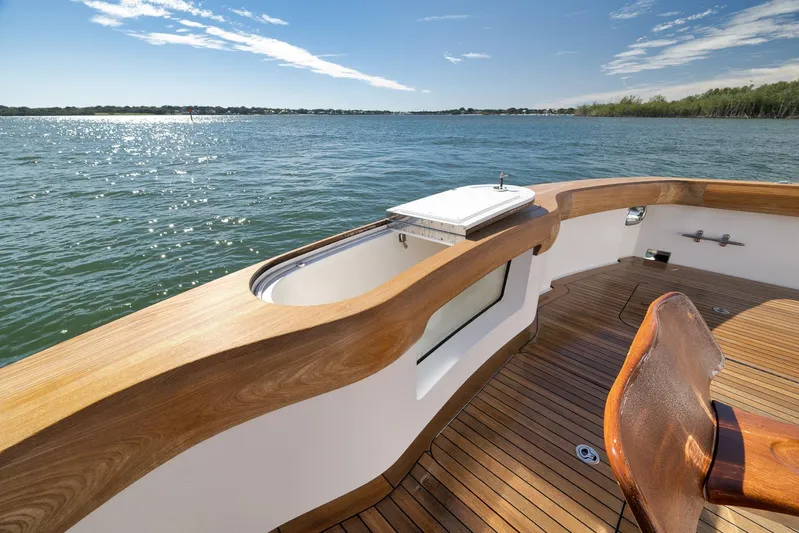 "slim Shady" Yacht Photos Pics Luxurious 2015 Hatteras GT70 yacht deck with wooden finish, overlooking serene waters.