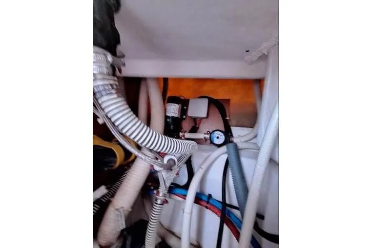 Bermuda Yacht Photos Pics Engine compartment of 2017 Dufour 412 Grand Large sailboat, showing hoses and mechanical components.