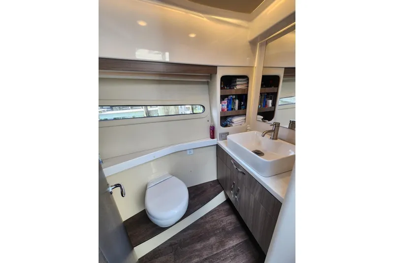  Yacht Photos Pics Modern bathroom in 2020 Regal 38 XO yacht with sink, toilet, and storage shelves.