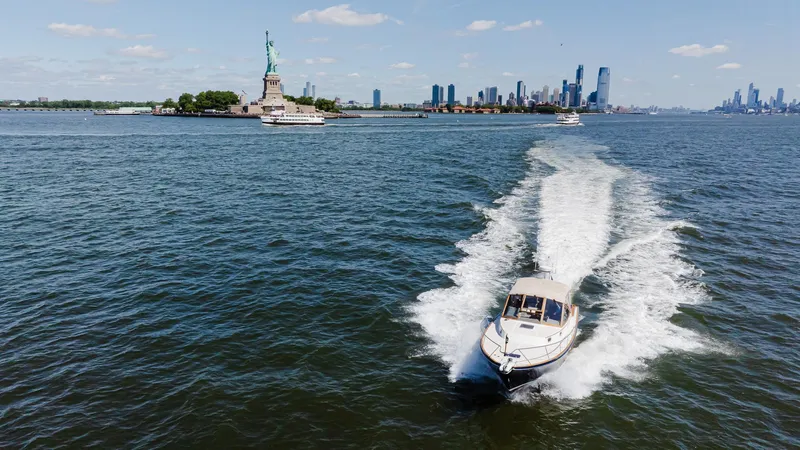 Freestyle Yacht Photos Pics Little Harbor WhisperJet 38 cruising near Statue of Liberty, New York City skyline in background.