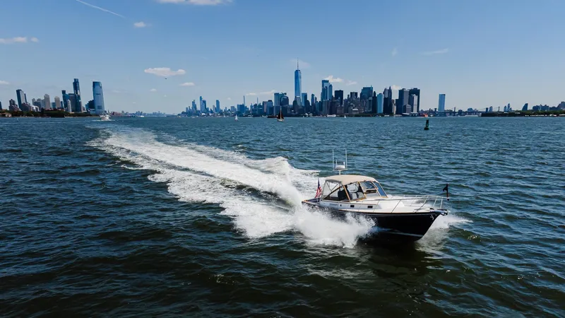 Freestyle Yacht Photos Pics 1998 Little Harbor WhisperJet 38 cruising on water with city skyline in background.