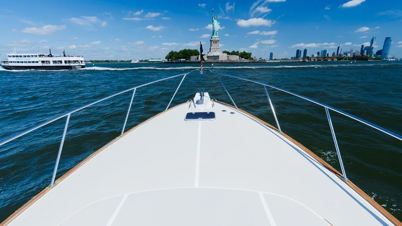 Freestyle Yacht Photos Pics Bow of 1998 Little Harbor WhisperJet 38 approaching Statue of Liberty on sunny day.