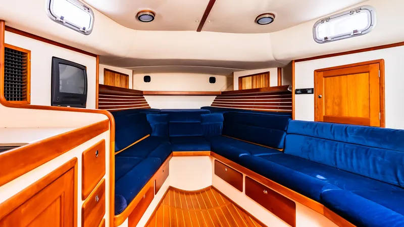 Freestyle Yacht Photos Pics Interior of 1998 Little Harbor WhisperJet 38, featuring blue seating and wooden accents.