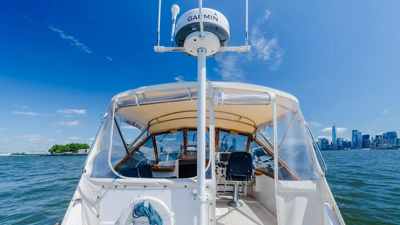 Freestyle Yacht Photos Pics Little Harbor WhisperJet 38 boat on water with city skyline in background, clear blue sky.