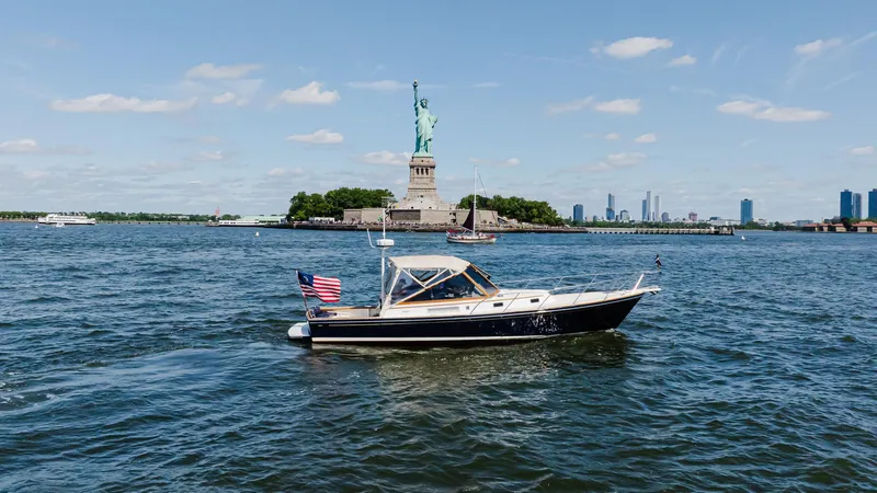 Freestyle Yacht Photos Pics Little Harbor WhisperJet 38 boat near Statue of Liberty, 1998 model, on a sunny day.