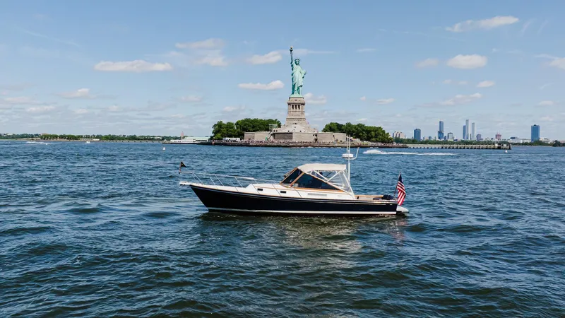 Freestyle Yacht Photos Pics Little Harbor WhisperJet 38 boat near Statue of Liberty, 1998 model, on a sunny day.