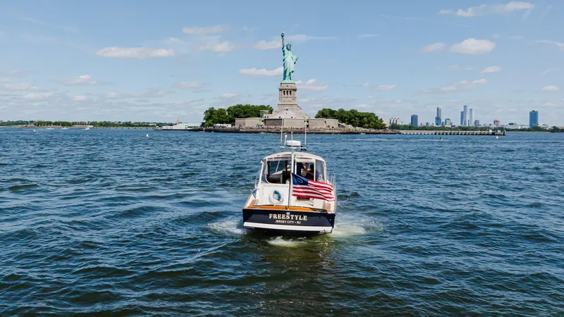 Freestyle Yacht Photos Pics Little Harbor WhisperJet 38 boat near Statue of Liberty, 1998 model, with American flag.