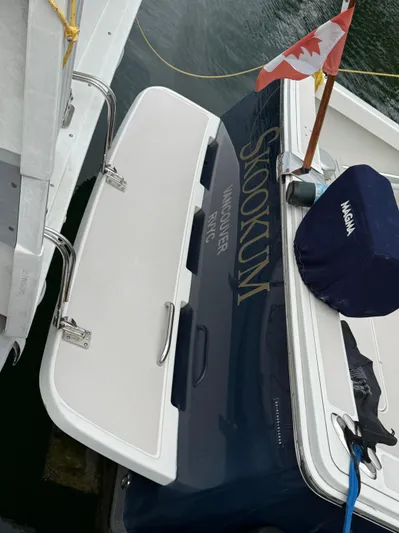 Skookum Yacht Photos Pics 2009 Back Cove 29 boat docked, featuring Canadian flag and "Skookum" name on stern.