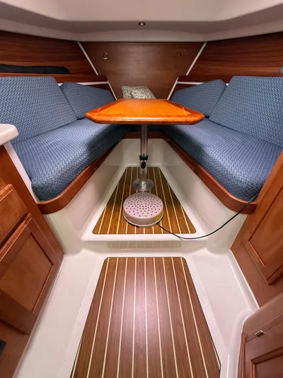 Skookum Yacht Photos Pics 2009 Back Cove 29 interior with blue seating, wooden table, and striped flooring.