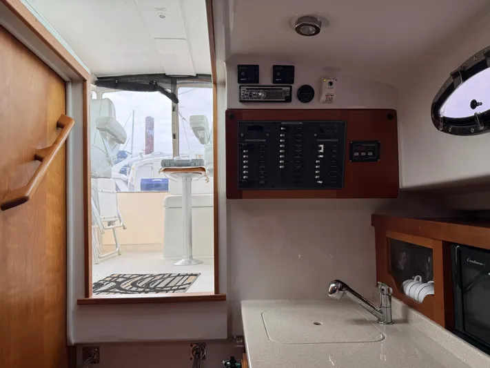 Skookum Yacht Photos Pics 2009 Back Cove 29 interior with control panel, sink, and outdoor seating view.