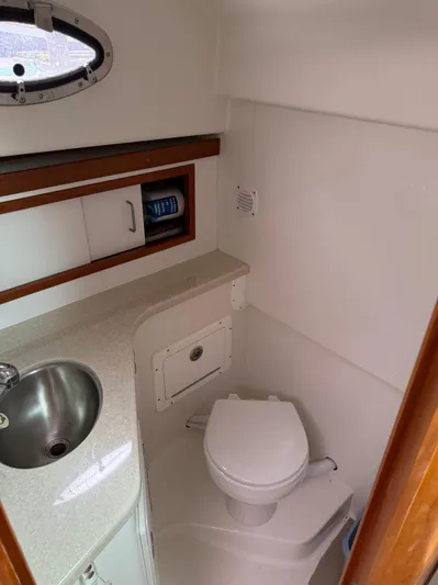 Skookum Yacht Photos Pics 2009 Back Cove 29 boat bathroom with sink, toilet, and storage cabinet.