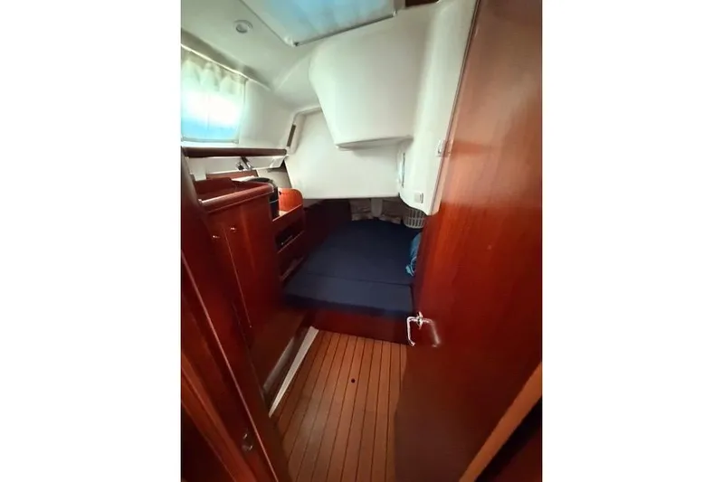 Solmare Yacht Photos Pics 2005 Beneteau Oceanis Clipper 423 cabin interior with wooden finish and blue bedding.