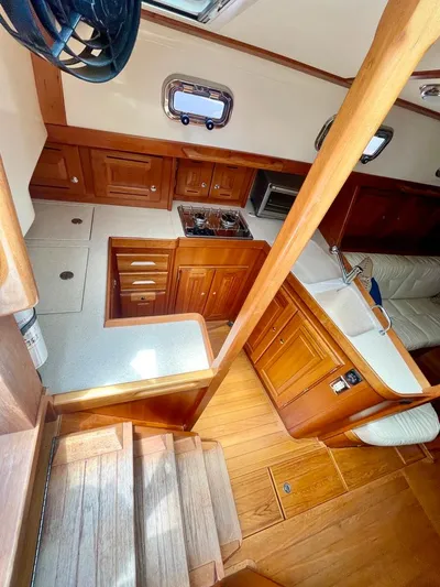 Tangaroa Yacht Photos Pics Interior of 2015 Tartan 4000 sailboat with wooden cabinetry and compact kitchen area.