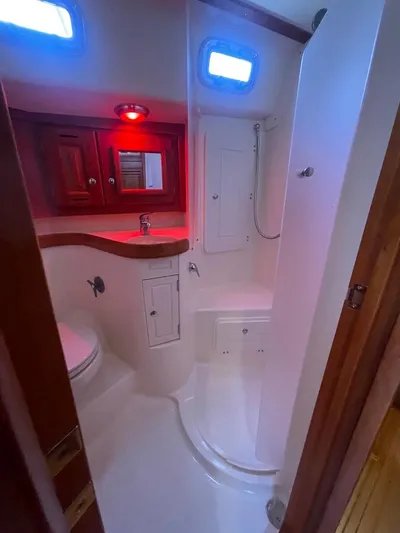Tangaroa Yacht Photos Pics 2015 Tartan 4000 yacht bathroom with shower, sink, and wooden cabinetry.