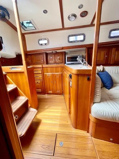 Tangaroa Yacht Photos Pics Interior of 2015 Tartan 4000 sailboat with wooden cabinetry and cozy seating area.