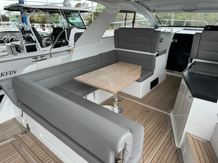  Yacht Photos Pics 2024 Sealine S335V yacht interior with gray seating and wooden table.