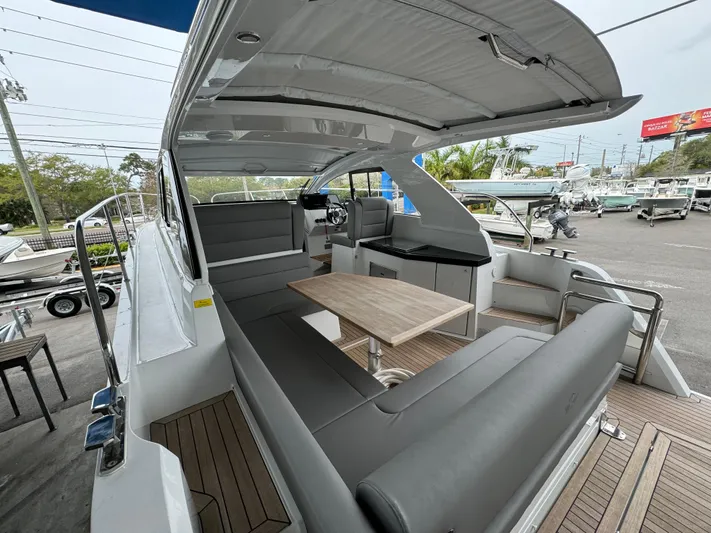  Yacht Photos Pics 2024 Sealine S335V yacht with spacious seating and modern design in a marina setting.