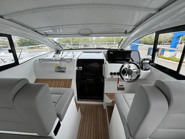  Yacht Photos Pics 2024 Sealine S335V boat interior with modern helm, seating, and wood flooring.