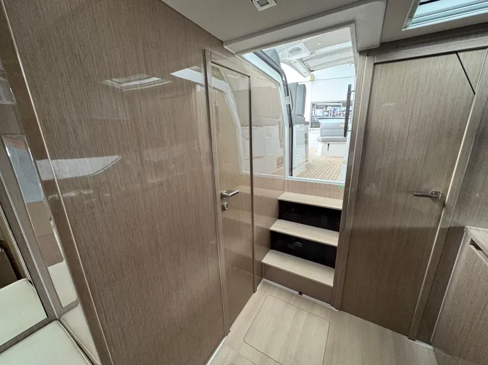  Yacht Photos Pics 2024 Sealine S335V yacht interior with wooden finish and steps leading to deck.