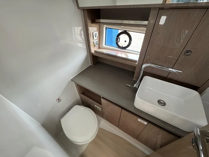  Yacht Photos Pics 2024 Sealine S335V yacht bathroom with modern sink, toilet, and wooden cabinetry.
