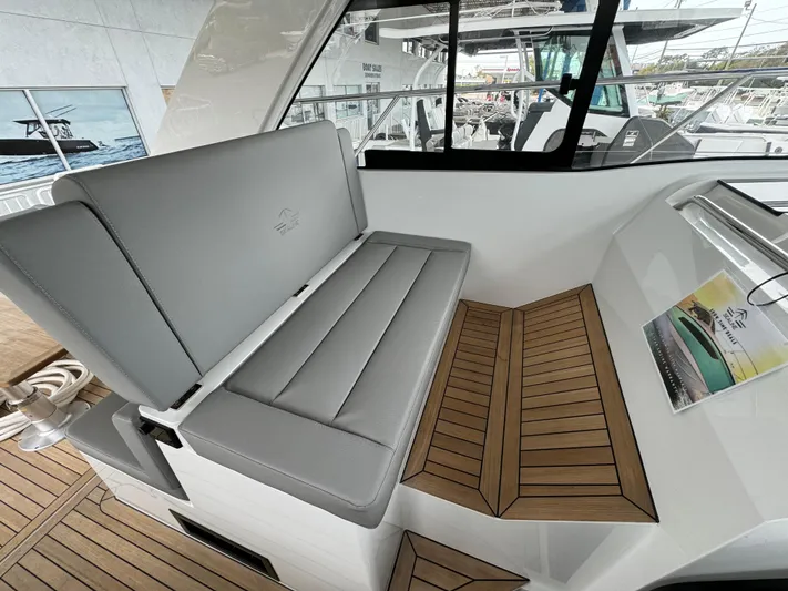  Yacht Photos Pics 2024 Sealine S335V boat interior with gray seating and wooden flooring.