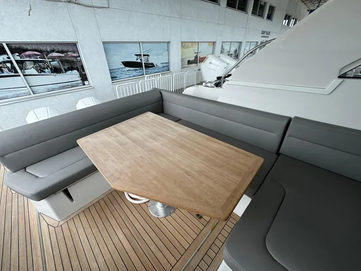  Yacht Photos Pics 2024 Sealine S335V yacht interior with wooden table and gray seating.