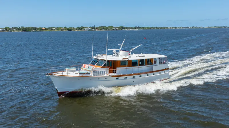 Absolute Yacht Photos Pics 1970 Trumpy houseboat cruising on open water under clear blue skies.
