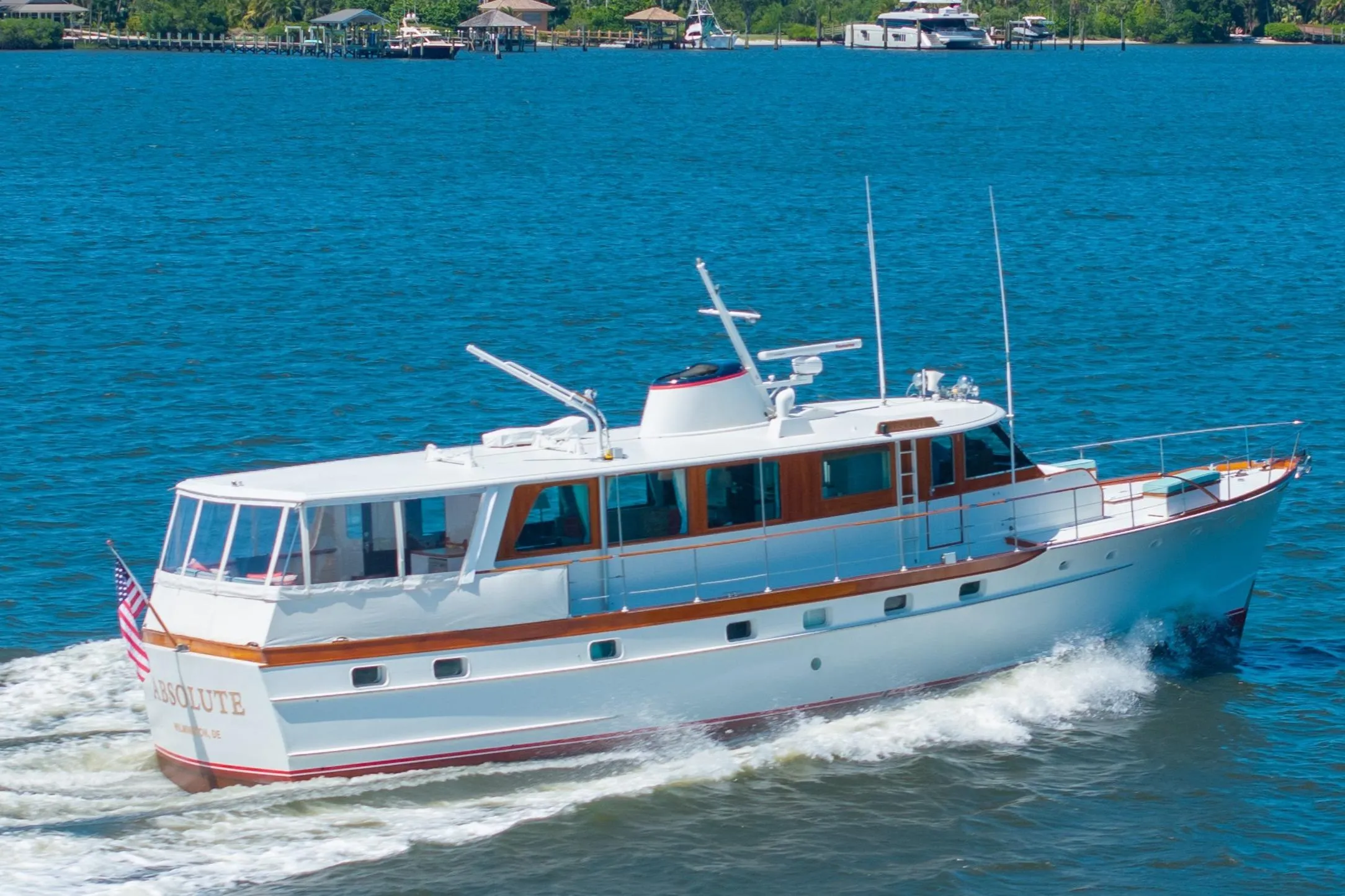 1970 Trumpy houseboat cruising on blue water, showcasing classic design and elegance.
