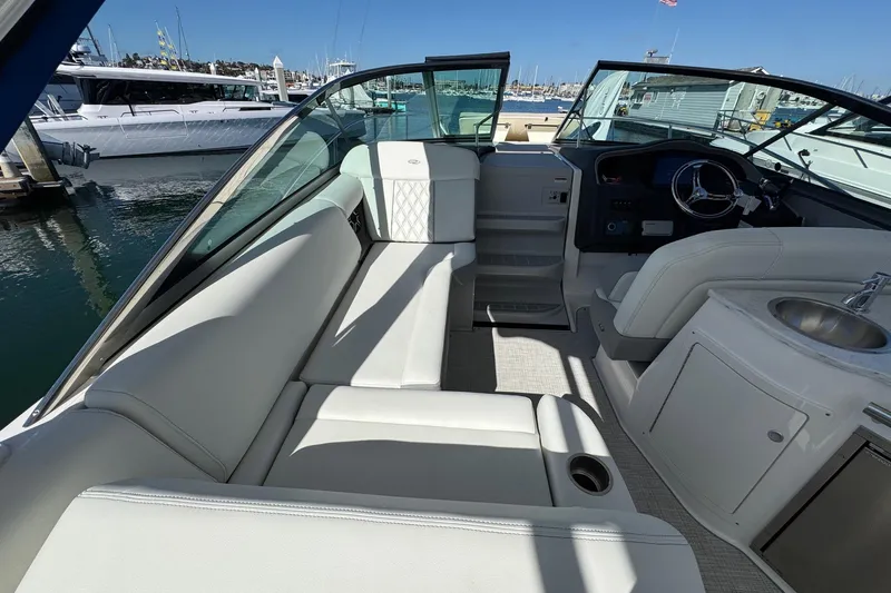 33 Xo Best Deals Of The Year!!1 Yacht Photos Pics 2026 Regal 33 XO boat interior with white seating, steering wheel, and sink at marina.
