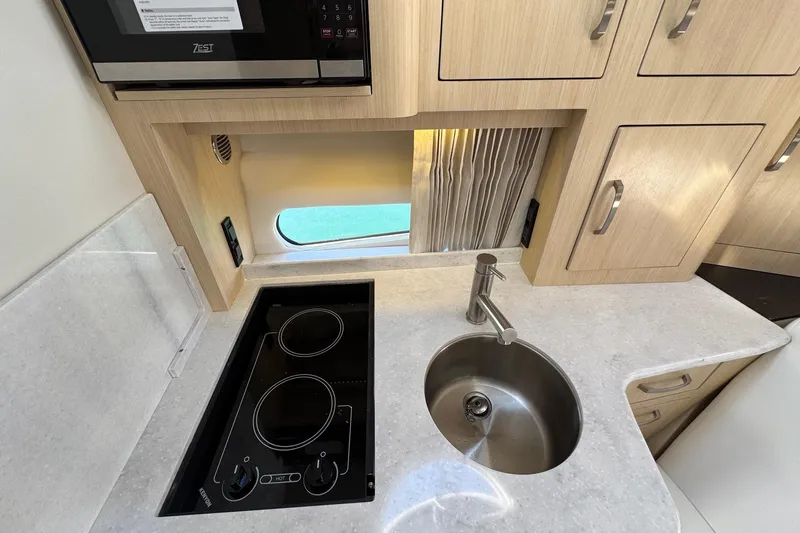 33 Xo Best Deals Of The Year!!1 Yacht Photos Pics 2026 Regal 33 XO yacht kitchen with stove, sink, and wooden cabinetry.