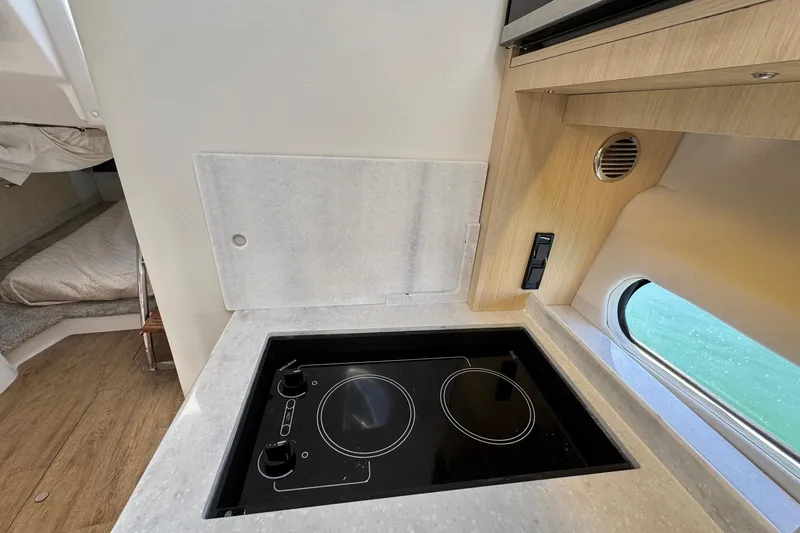 33 Xo Best Deals Of The Year!!1 Yacht Photos Pics Modern kitchen area in 2026 Regal 33 XO boat with electric cooktop and window view.