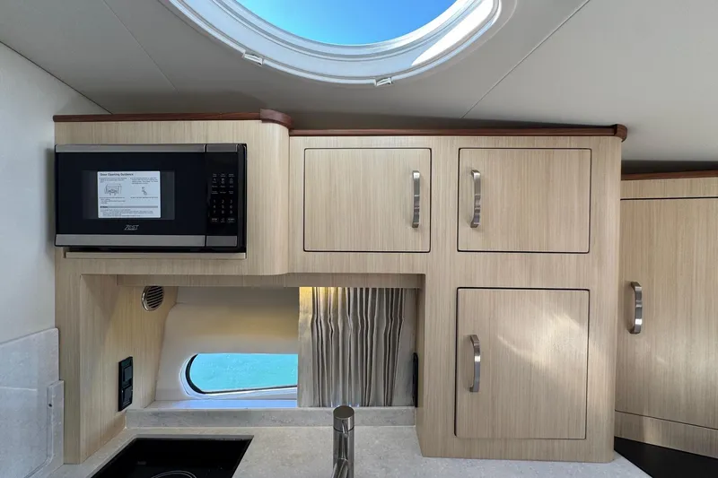 33 Xo Best Deals Of The Year!!1 Yacht Photos Pics Modern kitchen interior of 2026 Regal 33 XO boat with microwave and cabinets.