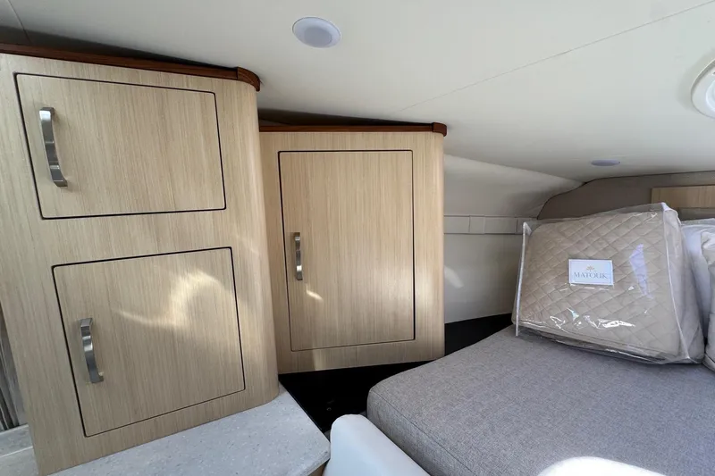 33 Xo Best Deals Of The Year!!1 Yacht Photos Pics Interior of 2026 Regal 33 XO boat with wooden cabinets and cozy bedding.