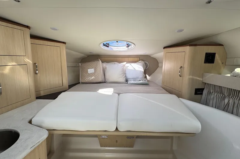 33 Xo Best Deals Of The Year!!1 Yacht Photos Pics Luxurious cabin interior of 2026 Regal 33 XO yacht with cozy bed and wooden cabinetry.