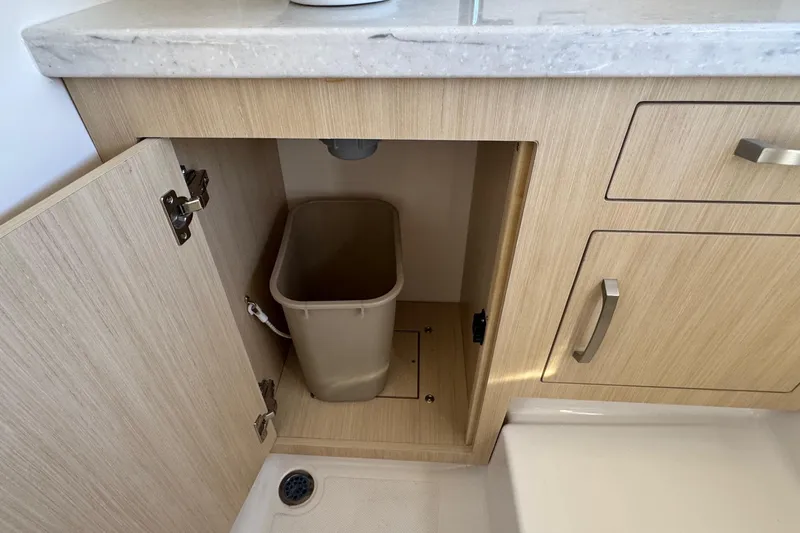 33 Xo Best Deals Of The Year!!1 Yacht Photos Pics Cabinet with trash bin inside Regal 33 XO 2026 model, featuring light wood finish.