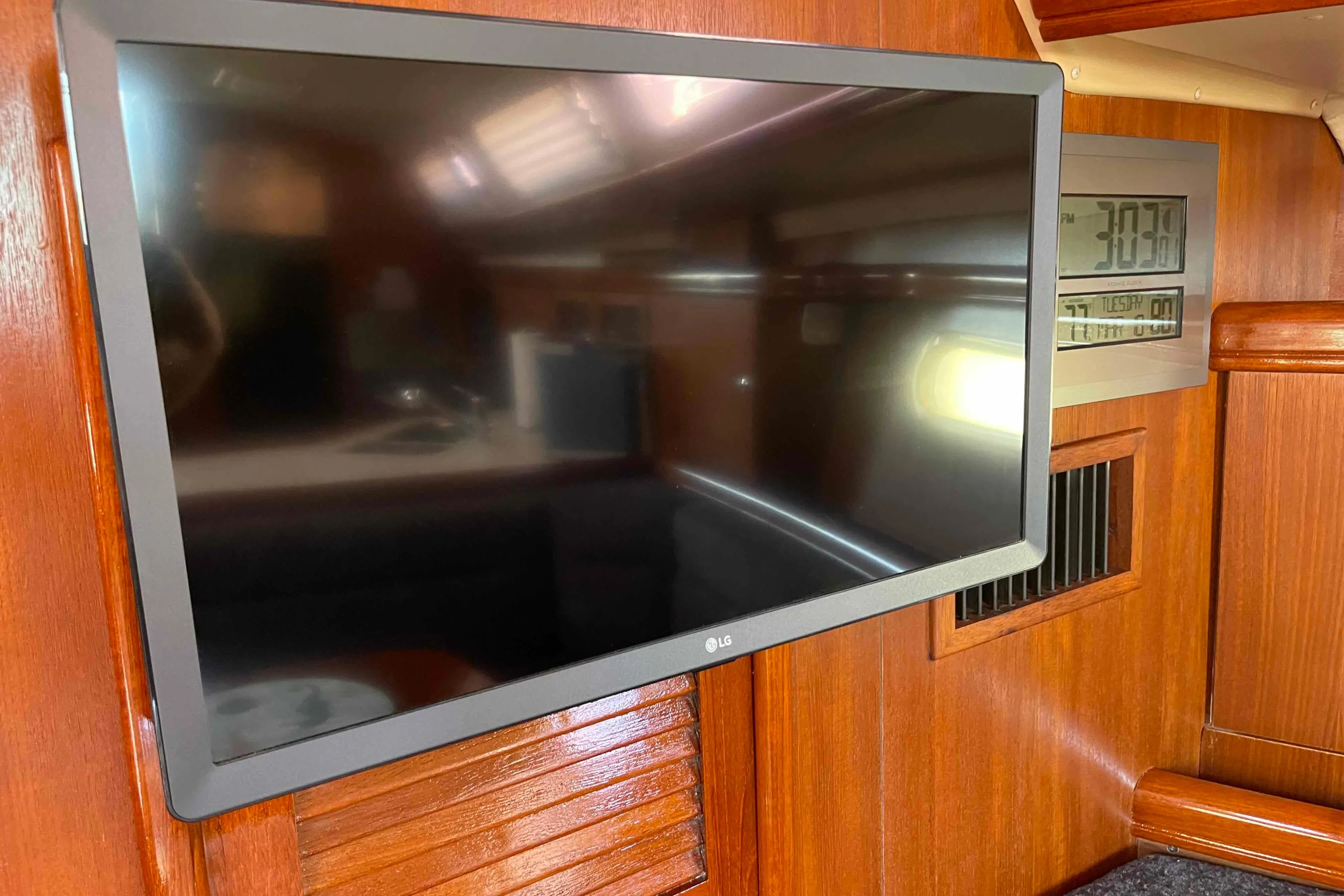 Flat-screen TV and digital clock inside 2006 Hunter 36 yacht cabin.